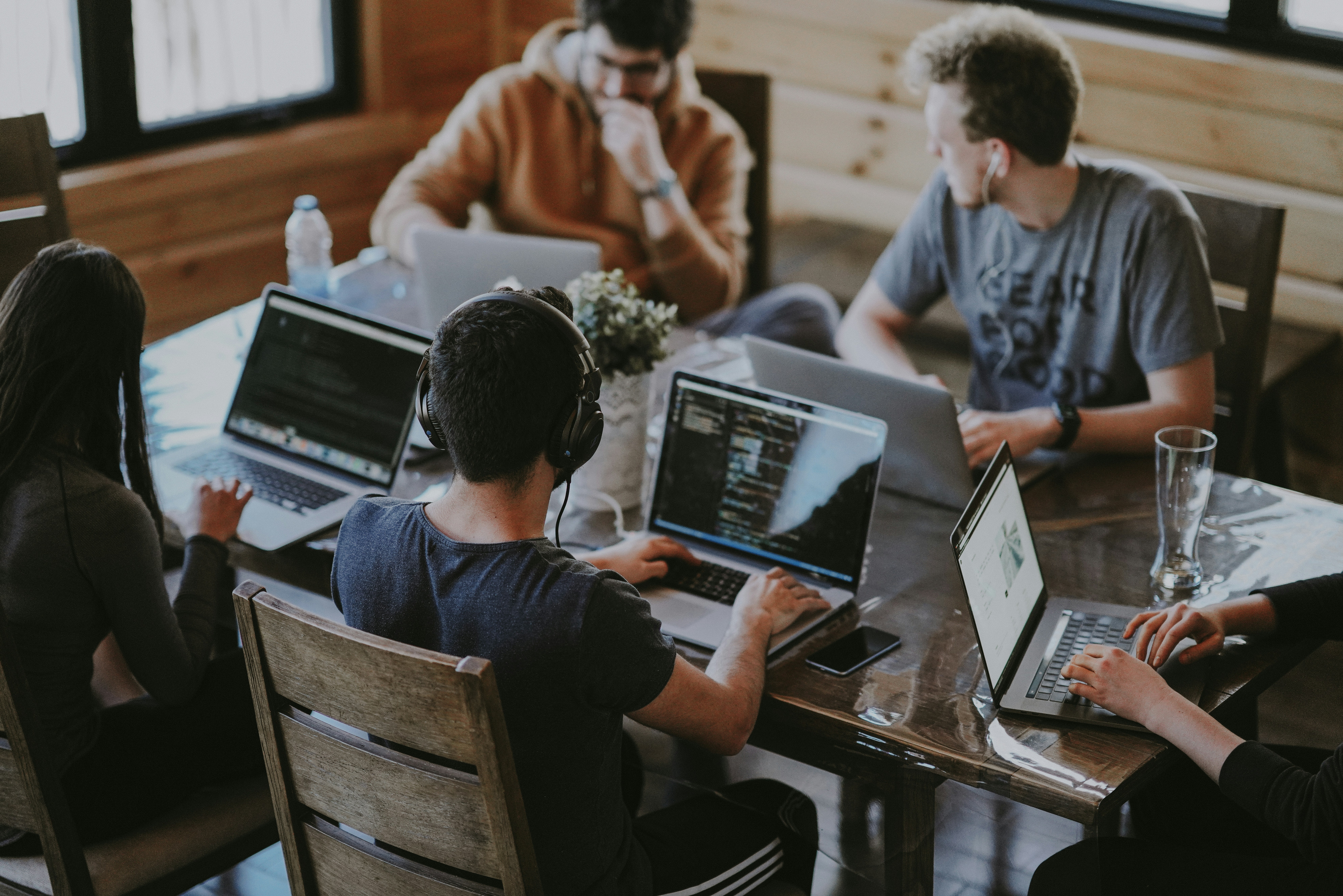 Group of people collaborating around a laptop, representing team relationships and trust in startups