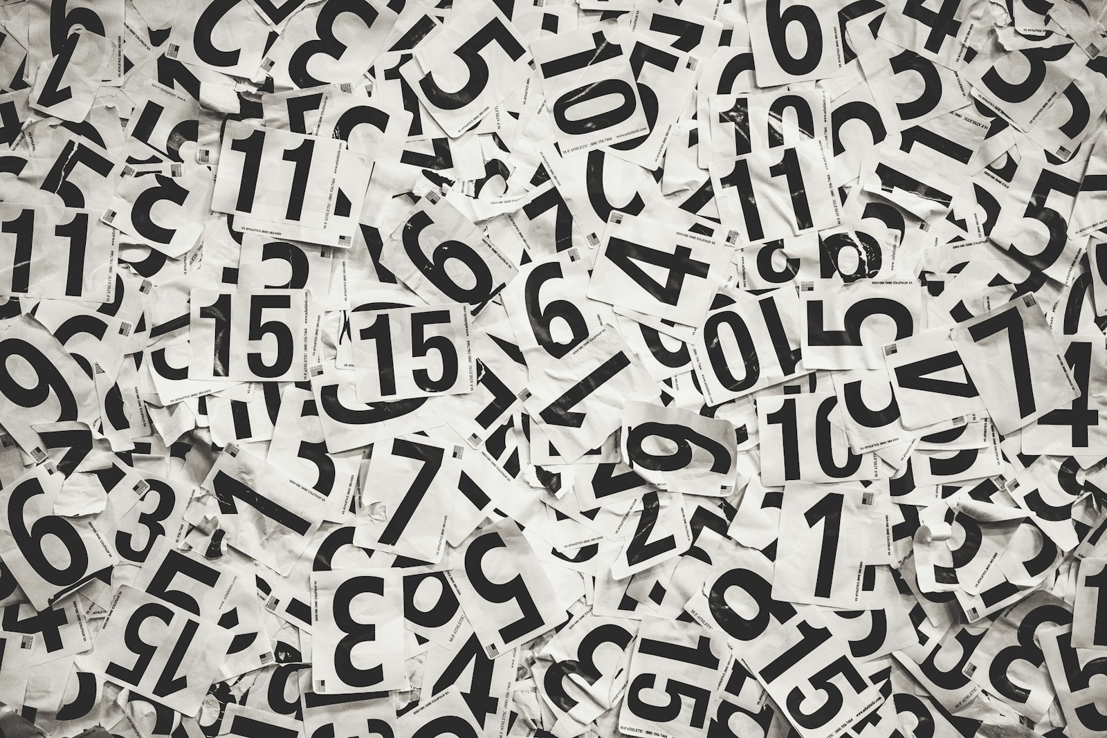 Scattered black numbers on a white paper background