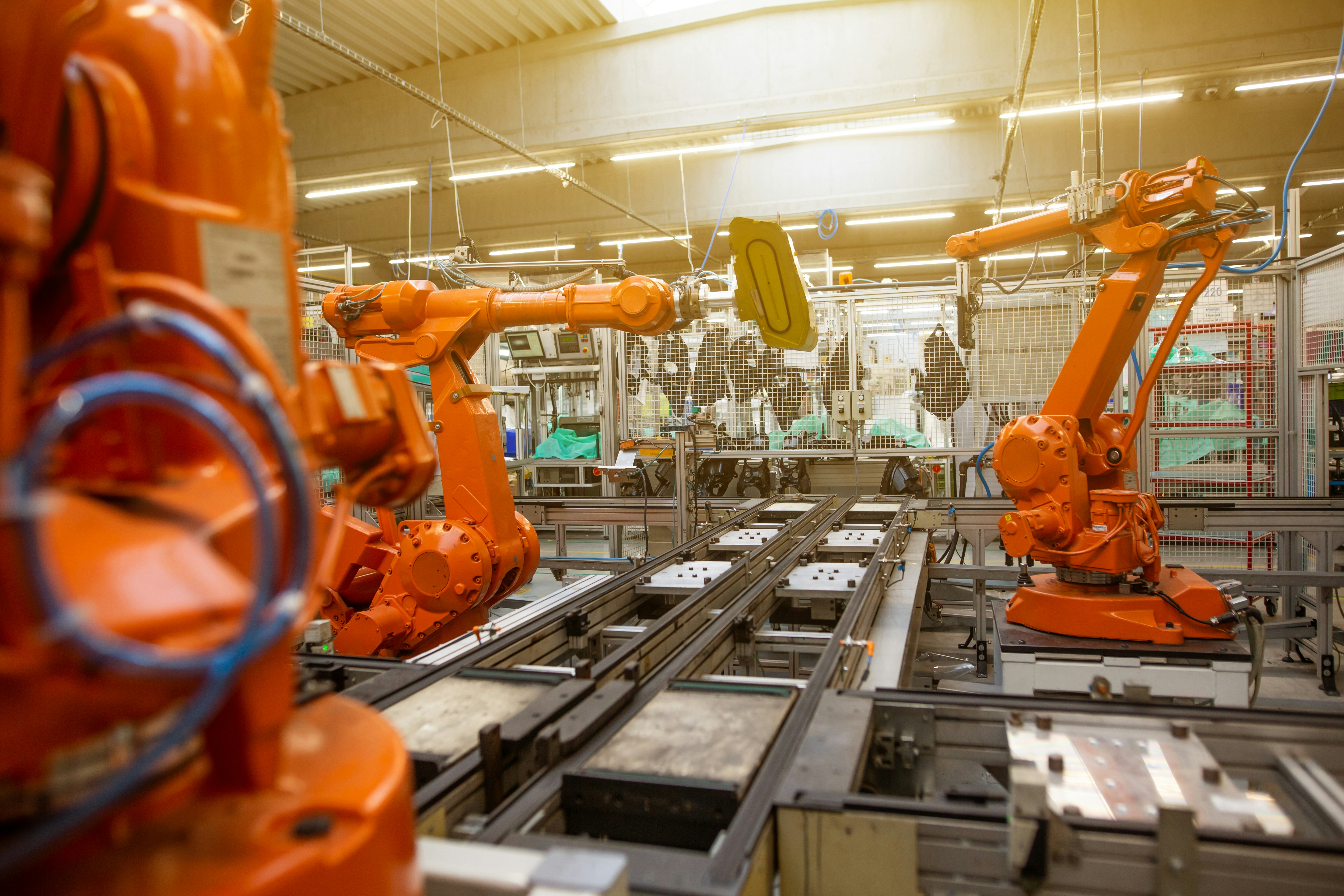Industrial automation robots working in a factory assembly line, representing automated workflow orchestration